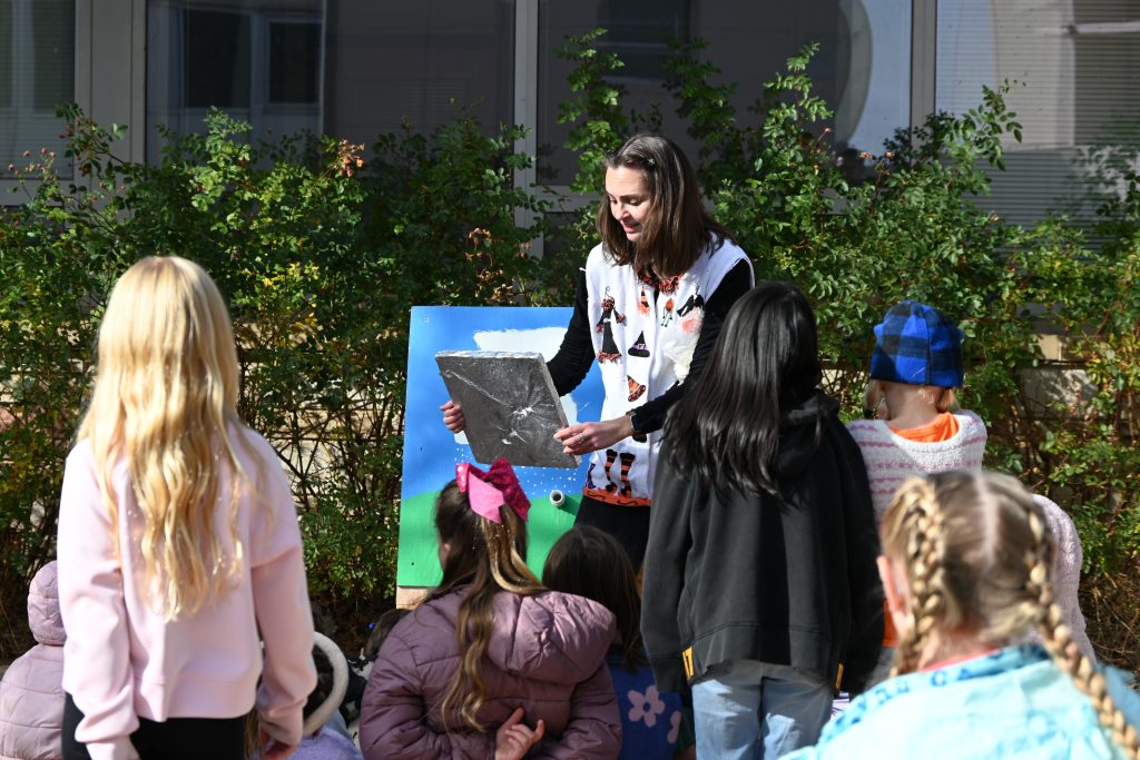 Person shows students a hail measurement pad