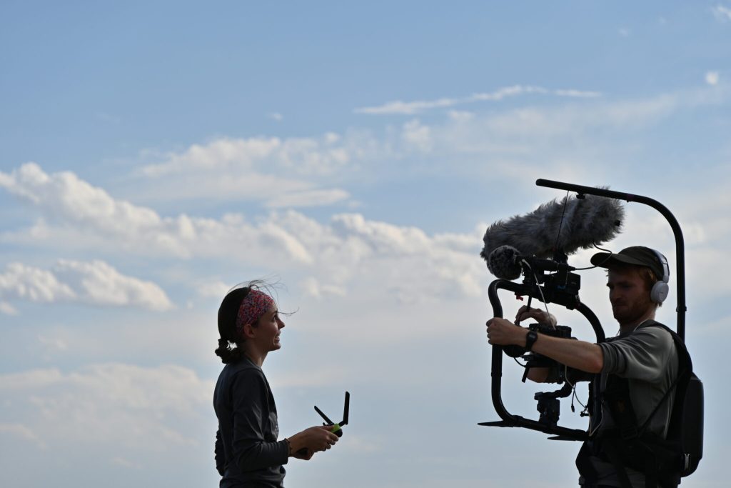 Person interviewing in front of camera crew outside