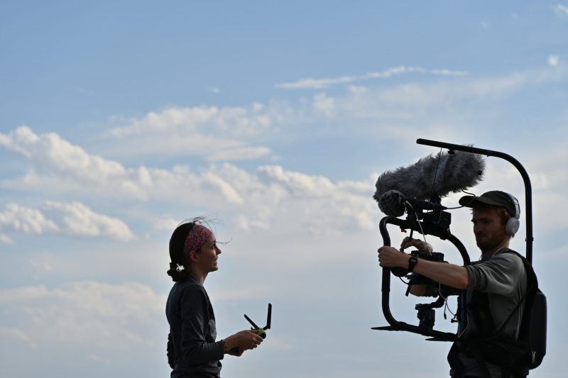 Person interviewing in front of camera crew outside