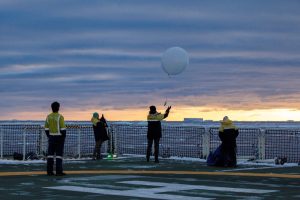 Chelsea and her team launch a weather balloon under a blanket of clouds