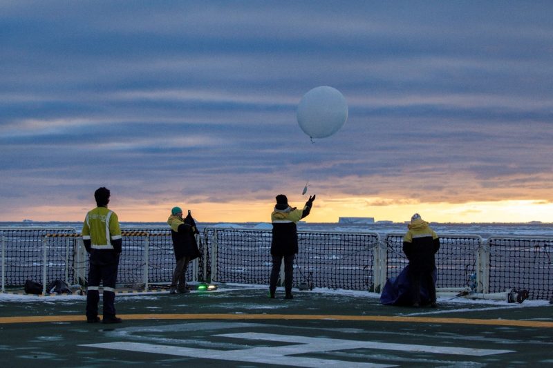 Chelsea and her team launch a weather balloon under a blanket of clouds